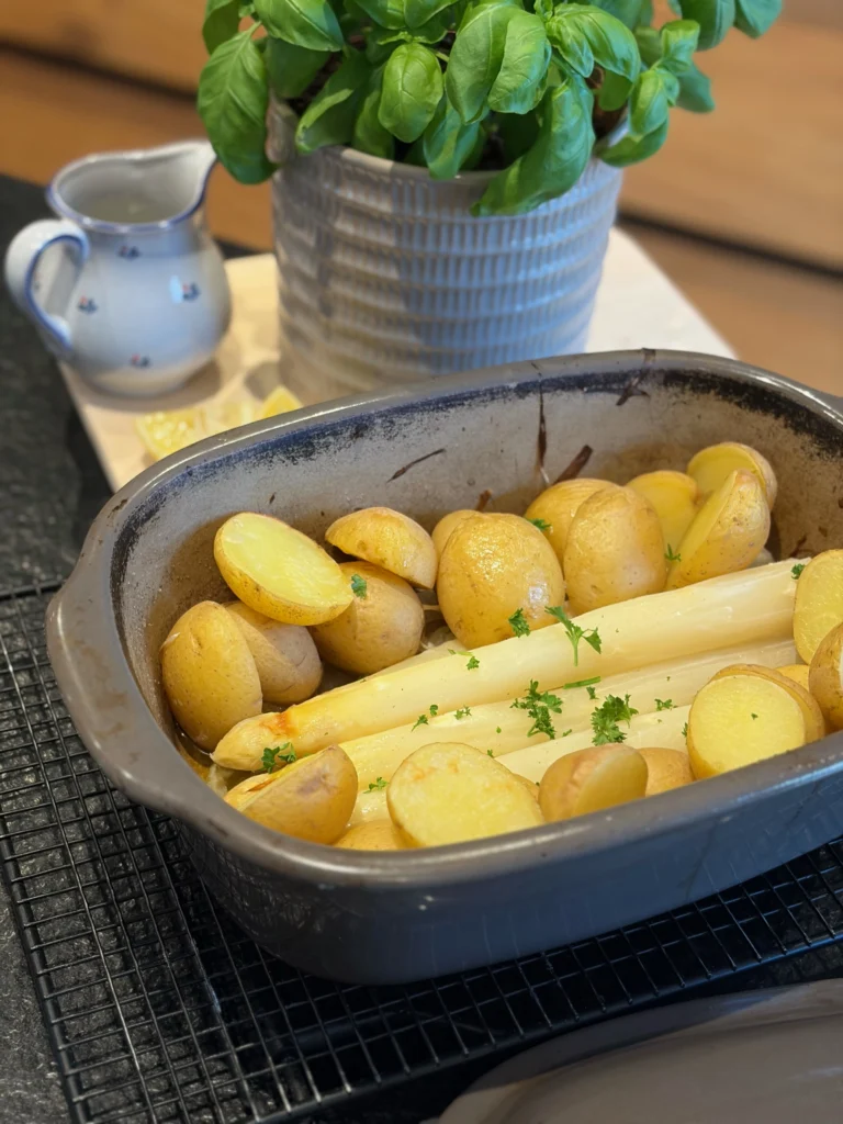 Frischer weißer Spargel mit goldbraunen Kartoffeln und Petersilie direkt im Pampered Chef Ofenmeister serviert